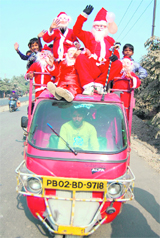 Santa Claus enjoys a ride on an autorickshaw in Amritsar on Thursday.