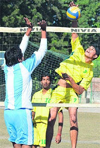 A player (in yellow) of GGD SD College, Hariana, spikes the ball during a match against PU Campus during the Panjab University Inter-College Volleyball (B-Division) Tournament for Men in Chandigarh on Thursday
