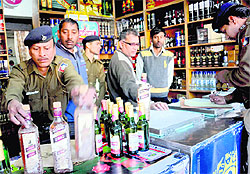 Policemen seize expired liquor bottles from a vend at Sector 19 in Chandigarh on Thursday