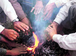 People warm themselve around bonfire in Gurgaon