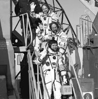 Expedition 30 Soyuz Commander Oleg Kononenko, bottom, NASA Flight Engineer Don Pettit of the US, and ESA (European Space Agency) Flight Engineer Andre Kuipers, top, wave farewell from the base of the Soyuz rocket at the Baikonur Cosmodrome in Kazakhstan, on Wednesday