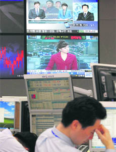 Foreign currency dealers take a break in front of TV screens airing reports on the death of North Korean leader Kim Jong-il at a dealing room of a bank in Seoul on Friday. The KOSPI closed higher on Friday to end the week on the upside, with positive US data stoking investor hopes of an economic recovery. 