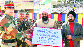 Brig Rajeev Sirohi, Commander of the Tithwal Brigade, with teachers of Government High School, Quila Drahal, in Rajouri on Friday.