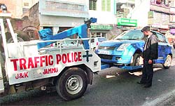 A special crane tows away a vehicle in Jammu