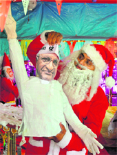 A man, dressed as Santa Claus, holds a cut-out of Anna Hazare during Christmas festivities in Ahmedabad on Friday. 