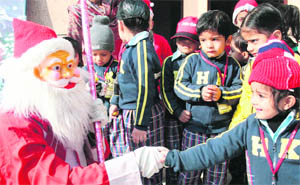 A schoolstudent shakes hand with a Santa Claus outside the St Marys Garrison Church in Gandhi Nagar on the eve of Christmas in Jammu on Saturday.