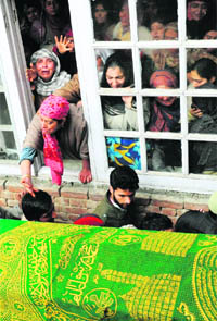 Relatives of NC worker Bashir Ahmad Dar grieve as the coffin containing his body is carried in a procession for funeral in Srinagar on Saturday. 