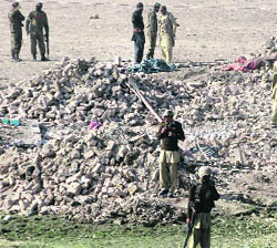 Security officials stand near the rubble of a paramilitary building levelled by a suicide bomb attack in Bannu on Saturday. 