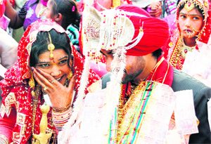 A couple waits for their wedding to be solemnised at a mass wedding ceremony organised by Nirmal Sewa Society on the occasion of Christmas in Amritsar on Sunday