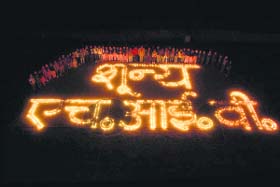 Youth of the Red Ribbon Club at Dronacharya College, Rait, use candles for presenting a special message of Zero HIV