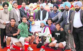 Chandigarh Hockey Academy team poses with the trophy after winning the 14th All India Mohinder Munshi Hockey tournament in Jalandhar on Saturday