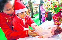 A devotee touches an idol of baby Jesus in the St Marys Garrison Church on Christmas in Jammu on Sunday