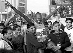 Officials of Ahmedabad fire and emergency services lift Kenyan runner Philemon Rotich after he won 'Sabarmati Marathon 2011' in Ahmedabad on Sunday. With over 9800 participants, including men