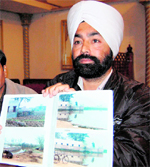 Jagmohan Singh shows pictures of some of ponds which have been encroached upon, in Amritsar.