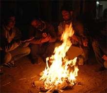 People keep themselves warm around a bonfire near the Bibiwala chowk on a cold Monday evening. Minimum temperature on Monday morning was 0.2 degree Celsius while the maximum temperature rose to 22 degree Celsius.