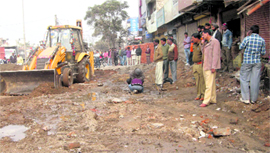 A JCB machine removes encroachments on NH-73 near Kamani Chowk, Yamunanagar, in the presence of a police force on Monday.