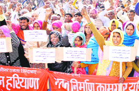 Workers of various labours unions stage a demonstration outside the Deputy Commissioner office in Bhiwani on Monday.