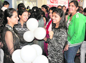 Students of Savitri Polytechnic Nehru Ground celebrate Christmas in Faridabad; and (right) a child dressed up as Santa Claus looks on at an image of Santa at a Church in Gurgaon.