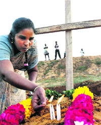 A relative lights candles at the grave of a victim of the Pulicat boat tragedy in Kumudipoondi, 60 km from Chennai, on Monday