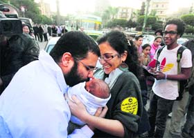 Alaa Abdel Fattah, a prominent blogger from Egypt, hugs his recently born son, Khaled, after he was released in Cairo on Sunday