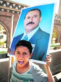 A supporter of Yemens outgoing President Ali Abdullah Saleh carries a poster during a demonstration to show support for him in Sanaa on Monday