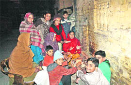 People warm their hands around a bonfire on a cold night on Tuesday in Hisar. 