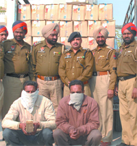 Policemen pose with the accused from whom illicit liquor and cash were seized in Jalandhar on Tuesday.