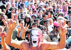 An anti-government protester, with his face painted in the colours of Yemens national flag, shouts slogans during a rally to demand that Yemen's outgoing President Ali Abdullah Saleh be tried, in Sanaa on Tuesday