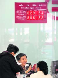 A board shows the current exchange rate between the renminbi and the US dollar and euro at a bank in Beijing on Wednesday