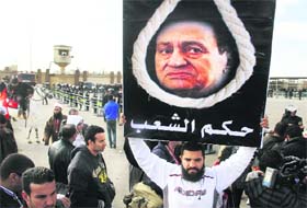 A man holds a placard depicting ousted President Hosni Mubarak in Cairo on Wednesday. The writing in Arabic says, "Trial of the people"