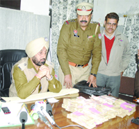 Police officials with the cash seized in Amritsar on Thursday. 