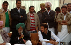 Gurdas Badal, speaks at a meeting, while his grandson Arjun Singh looks at him, while canvassing for the coming Assembly polls at the Lal Bai village in Lambi constituency on Thursday. 