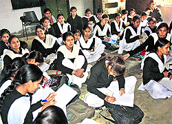 Girl students of government school, Model Town in Rohtak, sit on the floor inside a classroom
