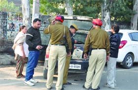 A police team searches a car near the District Administrative Complex on Thursday
