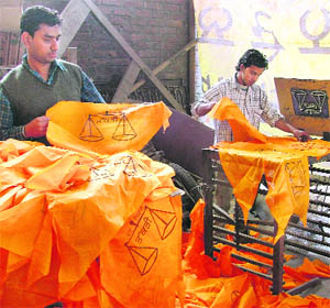 Workers prepare party flags in Ludhiana