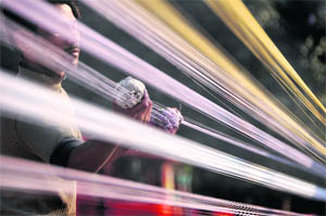 A man applies glass powder, a hardening substance, to a kite string in Ludhiana.