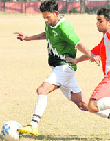 Players struggle during a football match at Sector 17, Chandigarh, on Friday. 