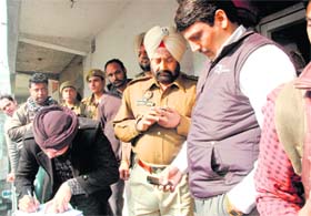 A drug inspector and police personnel outside the medical shop which was sealed by the authorities a few days ago