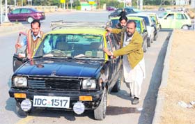 Cab drivers push a taxi in a long queue of vehicles for CNG in Islamabad on Monday
