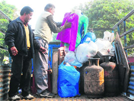 Members of the municipal corporation enforcement wing load seized material in a truck during an anti-encroachment drive in Sector 15, Chandigarh, on Monday.