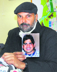 SSP Naunihal Singh shows a photograph of the prime accused, Rahul, in the siblings murder case at the police headquarters in Chandigarh on Monday.