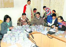Election officials count voter identity cards at the district election office in Dehradun on Monday.