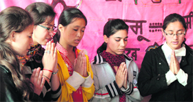 Ladakhi girls pray during the Losar (New Year) celebrations organised at DBN School at Mubarak Mandi in Jammu on Monday