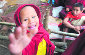 A young monk raises his hand towards the camera as Tibetan spiritual leader the Dalai Lama delivers a sermon on the second day of the Kalachakra Festival in Bodhgaya on Monday.