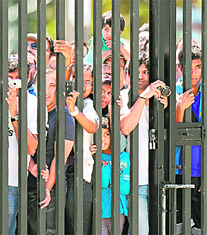 Fans watch the Indian team train from behind a gate during a practice session in Sydney on Monday. 