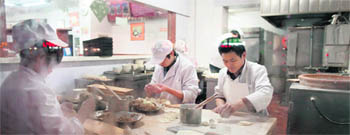 Chefs make dumplings inside a restaurant in Beijing on Tuesday.