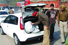 A policeman checks a vehicle as a security measure ahead of the assembly polls, in Bathinda