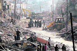 Debris being cleared after the demolition of buildings for the widening project on the Chakrata road in Dehradun on Tuesday