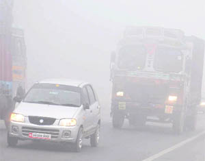 Vehicles ply at a snails pace in dense fog in Karnal on Tuesday.