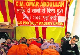 Members of the All-J&K PDD Daily Wagers Union on a relay fast in front of Chief Engineers office in Jammu on Tuesday